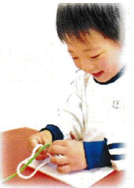 子供が紐結びをしている